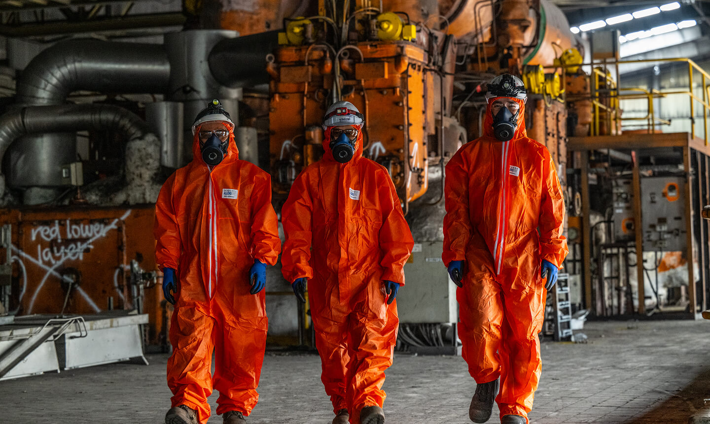Three people in hazmat suits